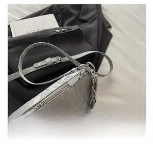 Detail showing smooth zipper and metallic silver crinkled leather texture with pearl chain