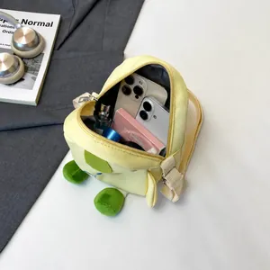 Internal storage capacity of yellow dinosaur canvas bag showing phones and cosmetics