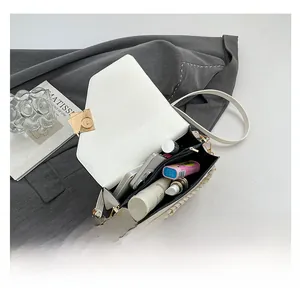 White envelope crossbody bag interior showing spacious storage for makeup and phone