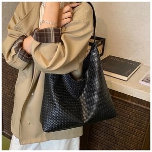 Close-up of black woven texture on a large hobo tote bag with a luxury leather finish