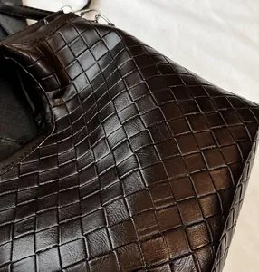 Close-up of deep brown woven leather texture on a bucket bag with premium finish