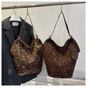 Detail of leopard print tote bags in brown faux suede with sturdy leather handles