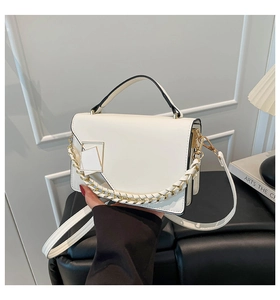 Detail of white PU leather handbag featuring gold metal handles and chunky chain strap