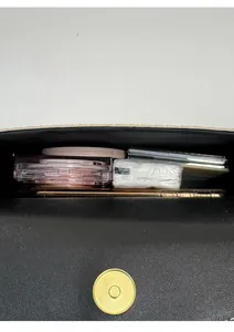 Top view of black crossbody bag interior showing storage space for phone and makeup