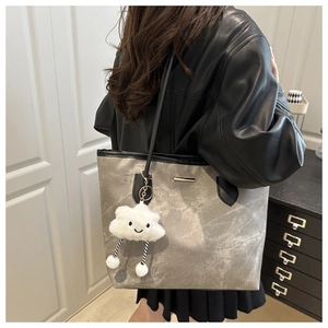 Grey marble texture tote bag with black handles and white cloud plush charm on model