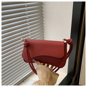 Donkerrode vierkante crossbodytas van getextureerd leer met knoopdetail op de schouder