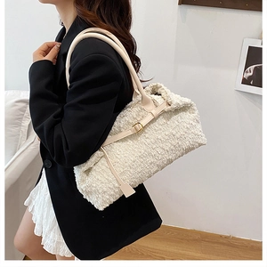 Close-up of beige bouclé texture and leather strap on a large shoulder tote bag