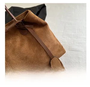 Detailed close-up of brown suede fabric and premium stitching on this vintage tote bag