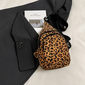 Detailed view of leopard print crossbody bag with multiple zipper compartments and wide strap