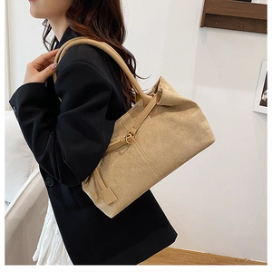 Detail of beige large-capacity shoulder bag with textured fabric and leather strap
