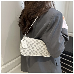 Detalle de bolso de silla beige con estampado de letras grises y hebilla de metal