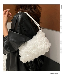 Détail des fleurs de roses 3D blanches sur un sac à bandoulière en résille porté