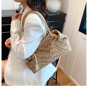 Detail of tweed textured shoulder bag with leather strap on a model in white blazer