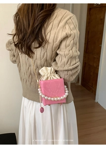 Pink croc-embossed square bag with pearl handle and golden chain on shoulder