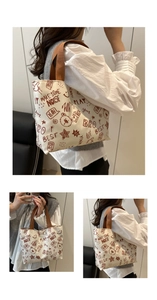 Detail of canvas tote bag with red-brown graffiti patterns and sturdy webbed handles