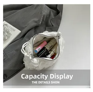 Vue de l'intérieur d'un sac à main blanc plissé montrant la capacité et le maquillage