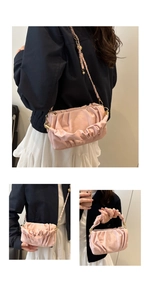 Detail of pink pleated crossbody bag showing soft leather texture and gold chain strap