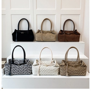 Collection of matte suede and tweed shoulder bags in various autumn colors on stairs