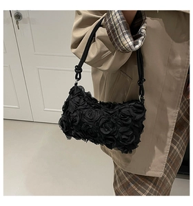 Détail du sac en maille à fleurs 3D noires avec élégante bandoulière à nœuds décoratifs