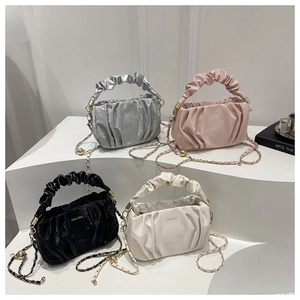 Detail of pleated cloud handbags in four colors with thick handles and metal chains