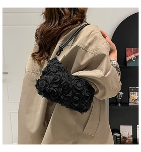 Détail de la texture rose 3D en résille sur un sac à bandoulière noir porté par un modèle