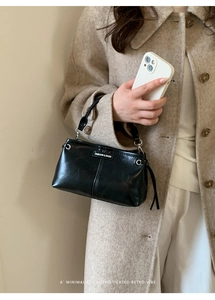 Λεπτομέρεια μινιμαλιστικής μαύρης δερμάτινης τσάντας με ρετρό στυλ και ασημένιους κρίκους
