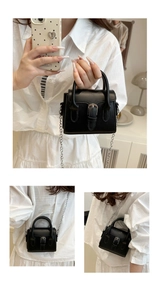 Detalle de mini bolso bandolera negro con hebilla plateada y correa de cadena
