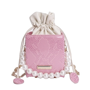 Mini borsa rosa effetto serpente con manico di perle e fodera a coulisse su fondo bianco