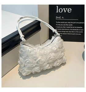 Détail de roses 3D blanches romantiques et fermeture argentée sur sac plissé épaule