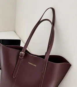Dettaglio borsa shopper bordeaux con tracolla regolabile e fibbia in metallo dorato