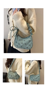 Détail du sac à bandoulière en velours côtelé bleu clair avec motifs nœuds et sangle plissée