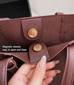 Dettaglio dell'interno di una borsa tote bordeaux con chiusura a scatto magnetico