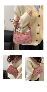 Détail du sac à bandoulière en velours rose avec nœuds noirs et anse froncée
