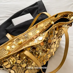 Close-up of smooth golden metal zipper and sparkling sequin detail on the tote bag