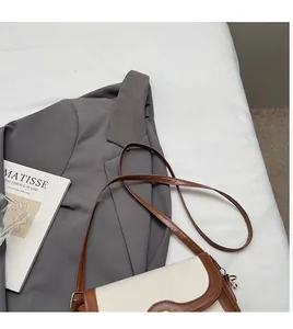 Detail of adjustable long brown leather strap and flap on a vintage crossbody bag