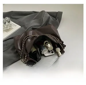 Top view of spacious interior of brown tote bag showing phone and cosmetics