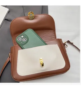 Detail view of vintage brown crossbody bag interior holding a smartphone and front pocket