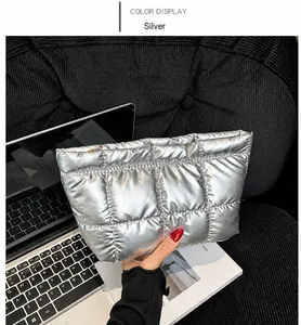 Detail of silver metallic quilted clutch bag with zipper and premium glossy finish