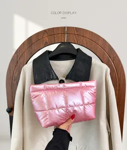 Detailed view of pink quilted padded clutch bag featuring shiny waterproof nylon fabric