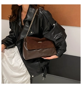 Detail of brown suede patchwork tote bag featuring golden chain strap and metal logo