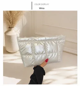 Detailed shot of a white quilted down-filled nylon handbag with a sleek zipper closure