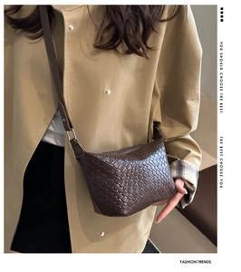 Detailed view of dark brown woven crossbody bag featuring textured vegan leather and strap