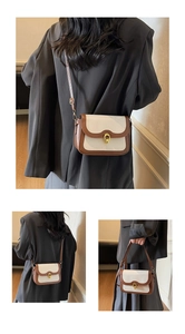 Detail of vintage crossbody bag with gold twist-lock closure and dual-tone leather paneling