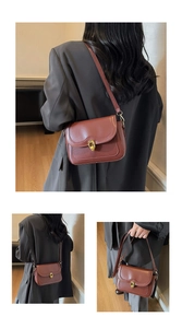 Close-up of a vintage dark reddish-brown leather crossbody bag with a golden metal buckle