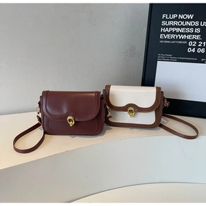 Detail view of retro crossbody flap bags with gold circular clasps on geometric stairs