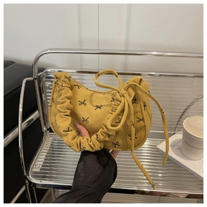 Yellow corduroy crescent shoulder bag with black bow print and ruched cloud handle