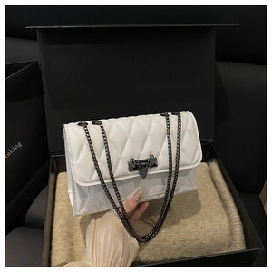 Dettaglio di una borsa a tracolla trapuntata bianca con catena e chiusura in metallo