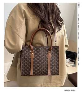 Borsa tote vintage marrone con motivo monogramma M e finiture dorate indossata da modella