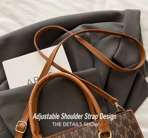 Dettaglio della tracolla regolabile e borsa a mano vintage con motivo monogram