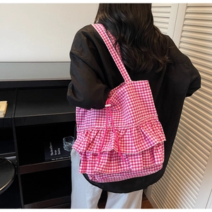 Detail of pink plaid tote bag with double-layer ruffle trim and functional drawstring